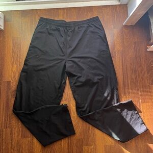 Men’s black wide legged sweat pants. With open zippers at the bottom.